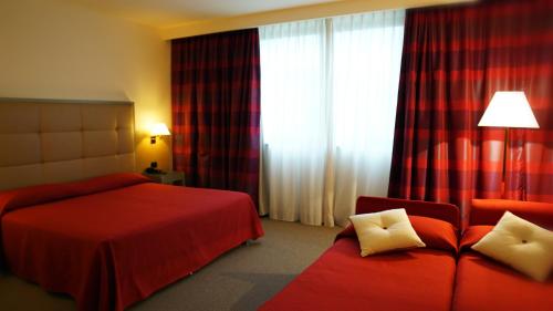 um quarto de hotel com uma cama, um sofá e uma janela em Garden Hotel em Arezzo