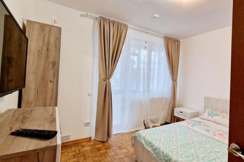 ein Schlafzimmer mit einem Bett und einem großen Fenster in der Unterkunft Belle Apartments - Bratianu in Piteşti
