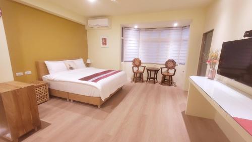 1 dormitorio con cama, mesa y TV en 九份慕心原宿 en Jiufen