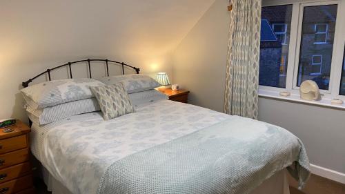a bedroom with a bed and a window at Apple Blossom Cottage - Spring Cottages, Cheddar in Cheddar