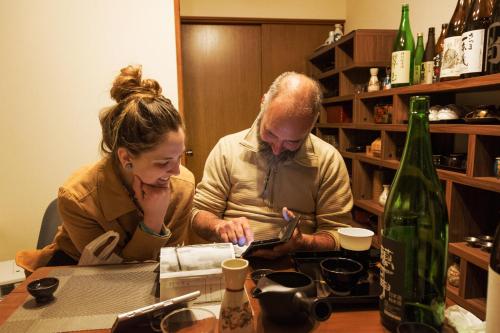 un hombre y una mujer sentados en una mesa en Live here like local Japanese do en Kirishima