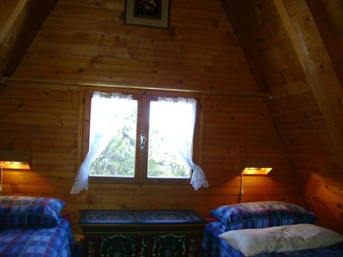 a room with two beds and a window in a cabin at Baita Giggia sulle piste - Cavalese in Trentino Alto Adige cottage chalet in Cavalese