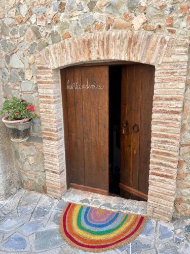 a door with a rainbow rug in front of a stone building at La Magara in Civita