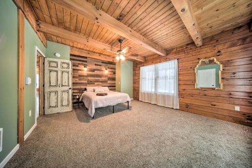 a bedroom with a bed in a room with wooden walls at Cabin in Lake Chautauqua on 36 Acres with Hot Tub! in Ashville