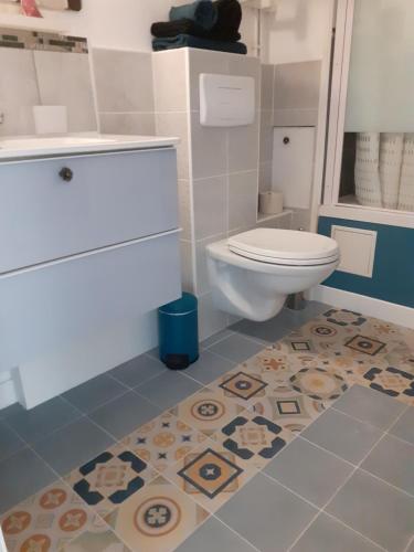 a bathroom with a toilet and a tile floor at Appartement T1 Hyper Centre avec Balcon in Bordeaux