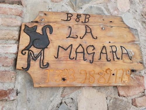 a sign with a black cat on a brick wall at La Magara in Civita