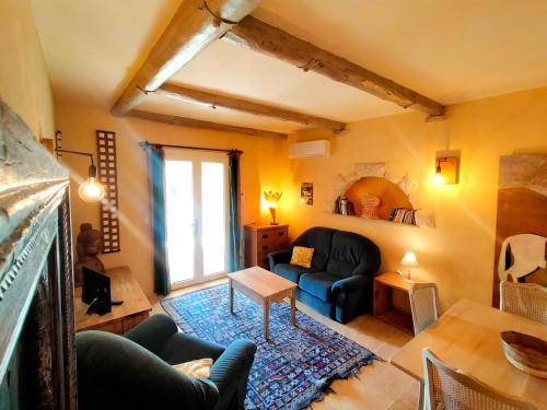ein Wohnzimmer mit einem Sofa und einem Tisch in der Unterkunft mas des broussonnetiers in Barjac