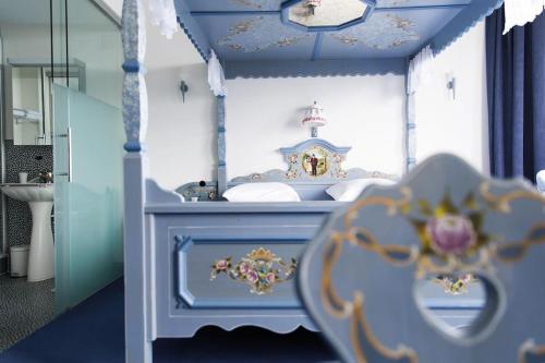 a bedroom with a blue and white bed with a sink at Komplettes Hotel mit 10 Zimmern in Bad Ragaz