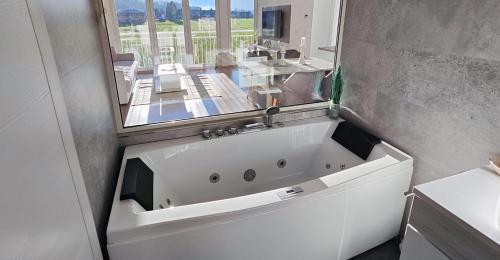 a white bath tub in a bathroom with a mirror at Unterschlupf in Ebensee
