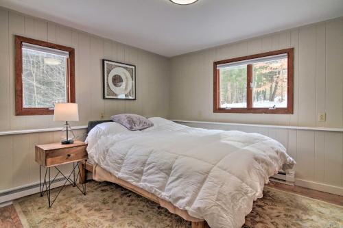 ein Schlafzimmer mit einem großen Bett und zwei Fenstern in der Unterkunft Inviting Vermont Cabin On Mount Ascutney! in Brownsville