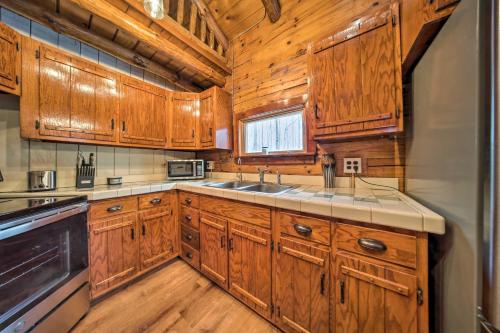 una cocina con armarios de madera y fregadero en Cambridge Springs Cabin Near French Creek!, en Cambridge Springs