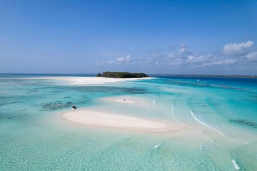 an island in the ocean with a sandy beach at Chunga Changa in Matemwe