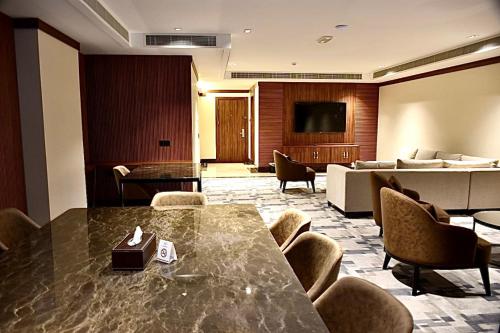 Royal Vista Hotel في عبري: قاعة اجتماعات مع طاولة وكراسي وأريكة