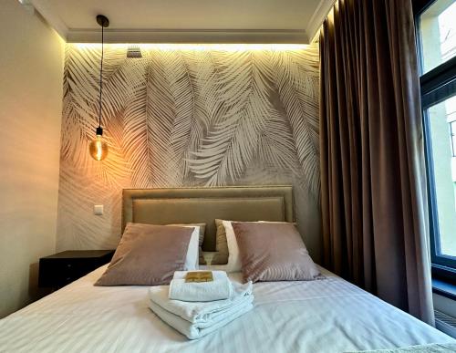 a bedroom with a bed with a large wall at PasteLove Okna in Toruń