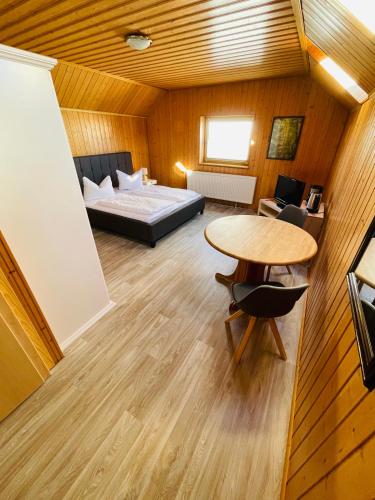 a room with a bed and a table and a bed at Brauhaus und Pension Babben in Lübbenau