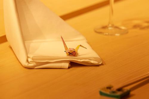 a toy butterfly sitting on a napkin on a table at THE skM TOKYO HOTEL & DINING in Tokyo
