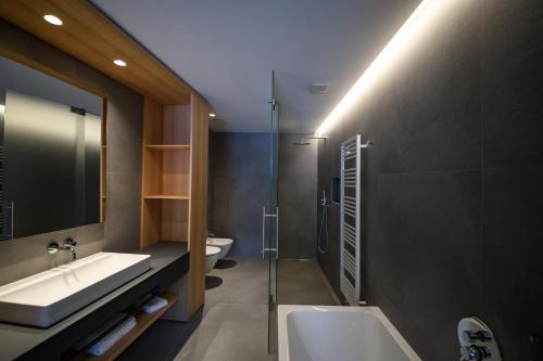 a bathroom with two sinks and a glass shower at Apartments Emilia in Ortisei