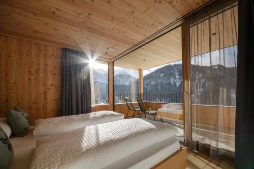 two beds in a room with a view of mountains at Apartments Emilia in Ortisei
