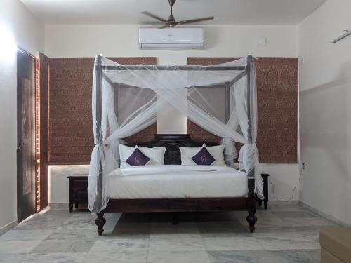 - une chambre avec un lit à baldaquin dans l'établissement Casa Blanca - A Boutique Resort, à Ahmedabad