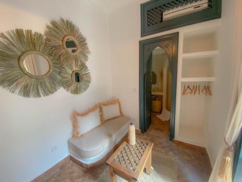 a living room with a bench and a mirror at Riad Dar Marrakcha in Marrakesh