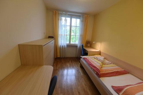 a small room with two beds and a window at Saint Ignatius Retreat House in Ljubljana