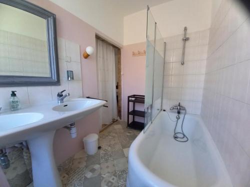a bathroom with a sink and a bath tub and a toilet at Maison Violette en Berry in Aigurande