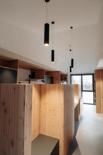 an open kitchen with wooden walls and pendant lights at L'Orée des Sources in Volvic