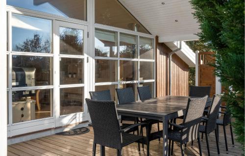 ein Holztisch und Stühle auf einer Terrasse in der Unterkunft Stunning Home In Rødby With Sauna in Rødby