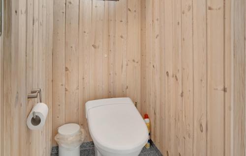 a bathroom with a white toilet in a wooden wall at Stunning Home In Rødby With Sauna in Rødby