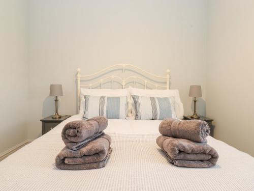 a bedroom with a bed with towels on it at Farnelea in Chathill