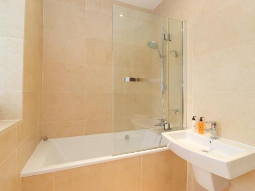 a bathroom with a tub and a sink and a shower at Farnelea in Chathill