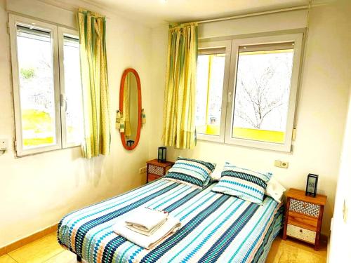 1 dormitorio con 1 cama con 2 almohadas y 2 ventanas en Departamento Valera, en Madrid