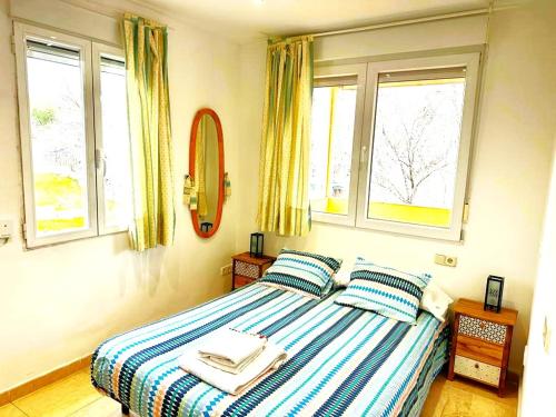 a bedroom with a bed with two pillows and two windows at Departamento Valera in Madrid