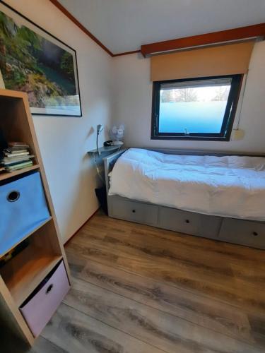 a small bedroom with a bed and a window at Chalet M & J in Heel