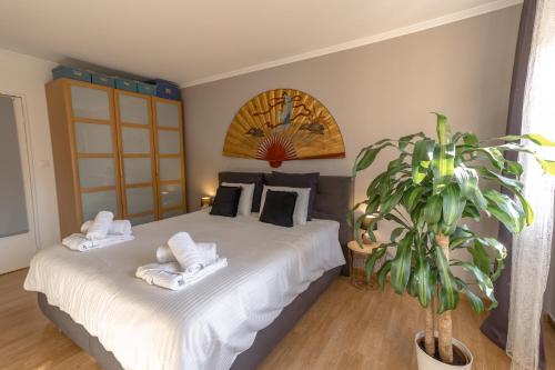 Un dormitorio con una cama con toallas y una planta en Le gîte de Sabina - Colmar, en Colmar
