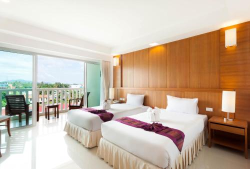 Rawai Princess Hotel tesisinde bir odada yatak veya yataklar