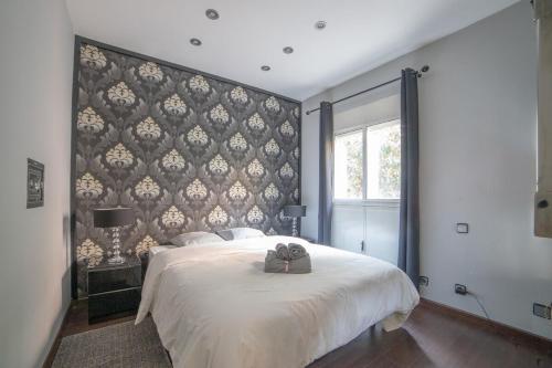 1 dormitorio con 1 cama grande y cabecero grande en MyHouseSpain - Moderno apartamento a escasos metros del Bernabeu en Madrid