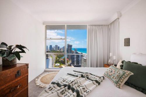 een slaapkamer met een bed en een groot raam bij Gold Coast 600 Fan Fav in Gold Coast