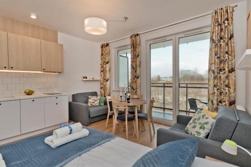 kuchnia i salon z łóżkiem i stołem w obiekcie BlueApart Apartamenty Hotelowe Nexo II w mieście Puck