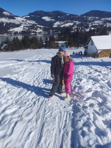 a couple of children standing in the snow at Cabana Busuioc in Colibiţa