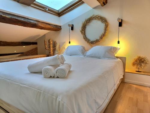 1 dormitorio con 1 cama blanca grande y toallas. en • L’Observatoire • Parking • Clim • Netflix • en Albi