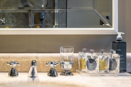 eine Theke mit einem Waschbecken mit Brille und einer Flasche Wasser in der Unterkunft Hotel Palazzo Priuli in Venedig