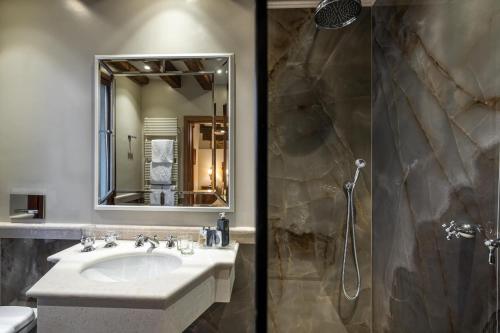 a bathroom with a sink and a shower with a mirror at Hotel Palazzo Priuli in Venice