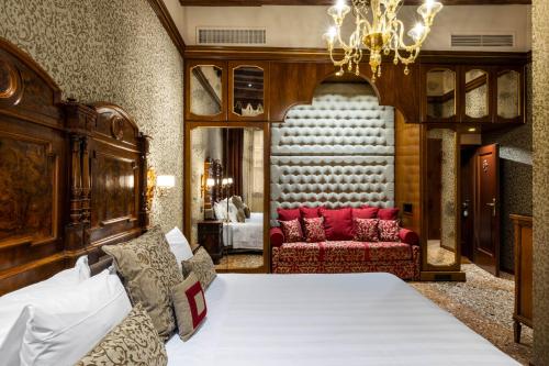 a bedroom with a bed and a chandelier at Hotel Palazzo Priuli in Venice