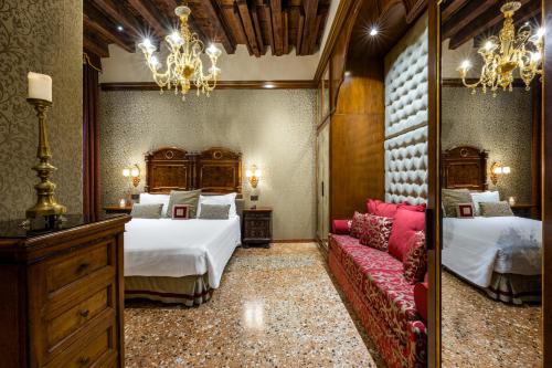 a bedroom with two beds and a couch and a mirror at Hotel Palazzo Priuli in Venice