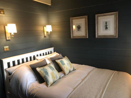 Highland cabin - relaxing hot tub في إينفيرنيس: غرفة نوم بسرير وجدران سوداء
