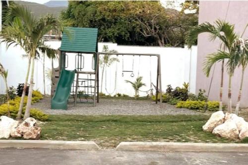 a playground with a green slide and a green chair at Comfy Seascape Retreat near Kingston Airport in Kingston
