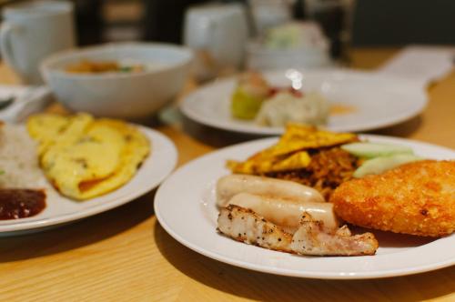 a wooden table with plates of food on it at Aviary Hanoi Hotel & Travel in Hanoi