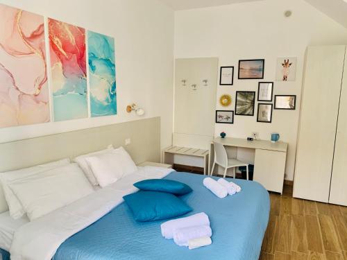 a bedroom with a blue bed with towels on it at Bed and Breakfast Arco dei cappuccini in Taormina