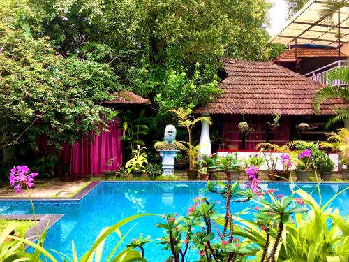 una piscina di fronte a una casa di Marari Dreamz Homestay a Mararikulam